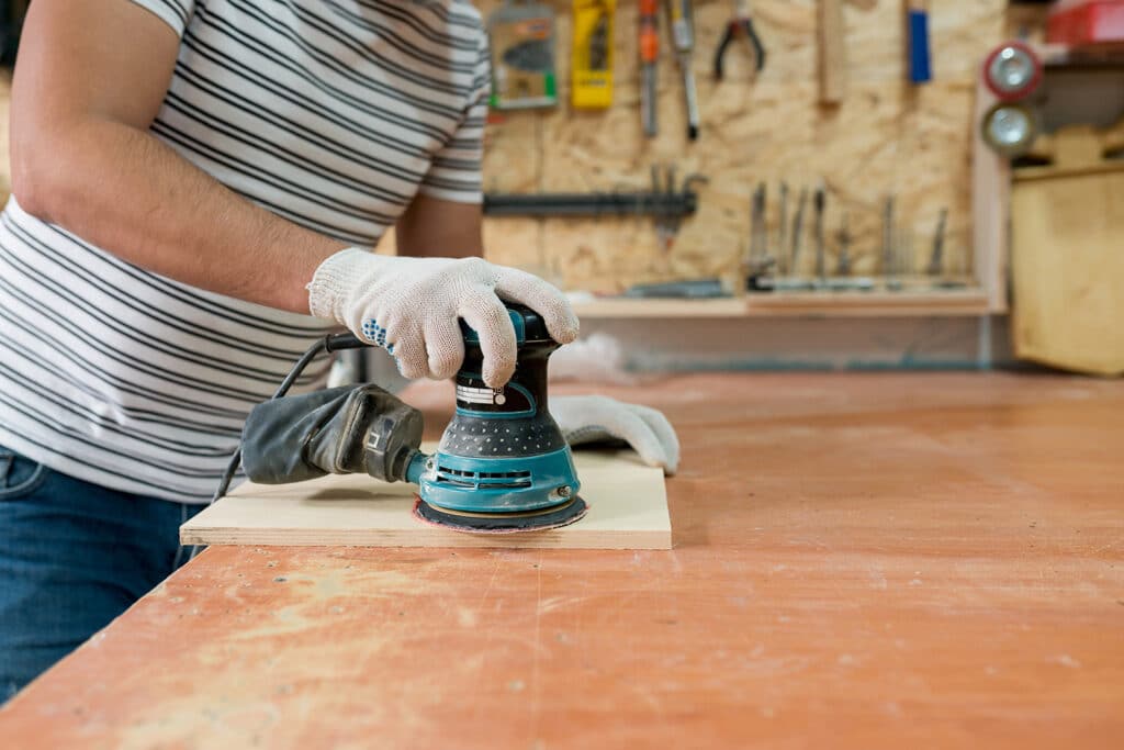 Image of home diy-er sanding a piece of wood